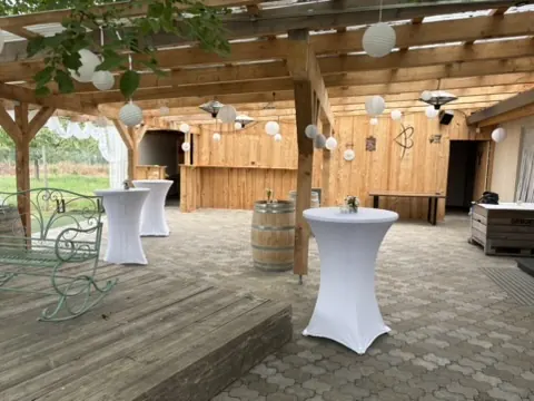 Stehtische mit weißen Hussen unter der Pergola